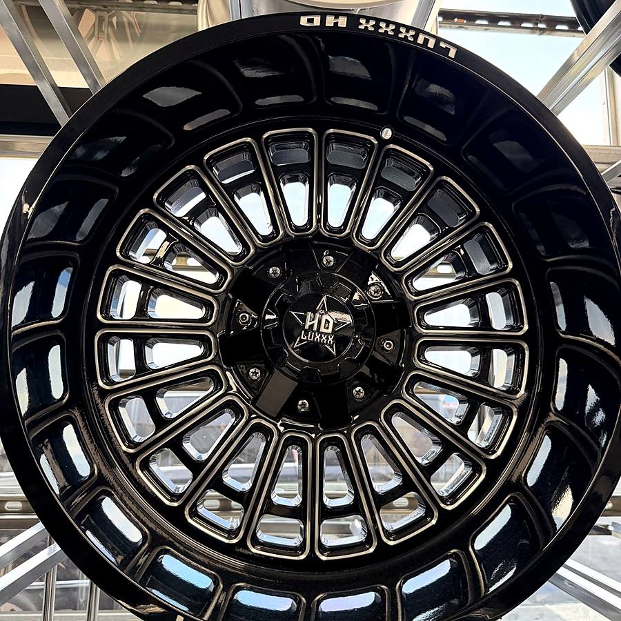 Luxxx HD gloss black truck wheel with milled windows on the wheel wall at Llantera Del Norte INC, 606 Peoria St, Aurora, Colorado / Rin de troca Luxxx HD negro brillante con ventanas fresadas en Llantera Del Norte INC en Aurora, Colorado