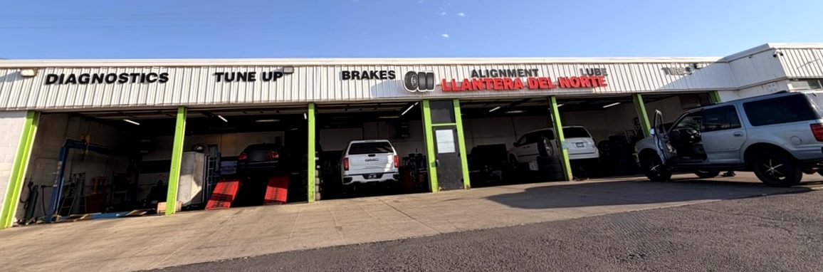Llantera Del Norte INC shop front at 606 Peoria St in Aurora, Colorado, showing service bays and signage for diagnostics, tune up, brakes, alignment and lube / Frente del taller Llantera Del Norte INC en el 606 de Peoria St en Aurora, Colorado, con las bahías de servicio y el letrero de diagnóstico, afinación, frenos, alineación y lubricación